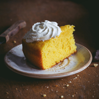 Pumpkin cake with whipped cream on plate. Square